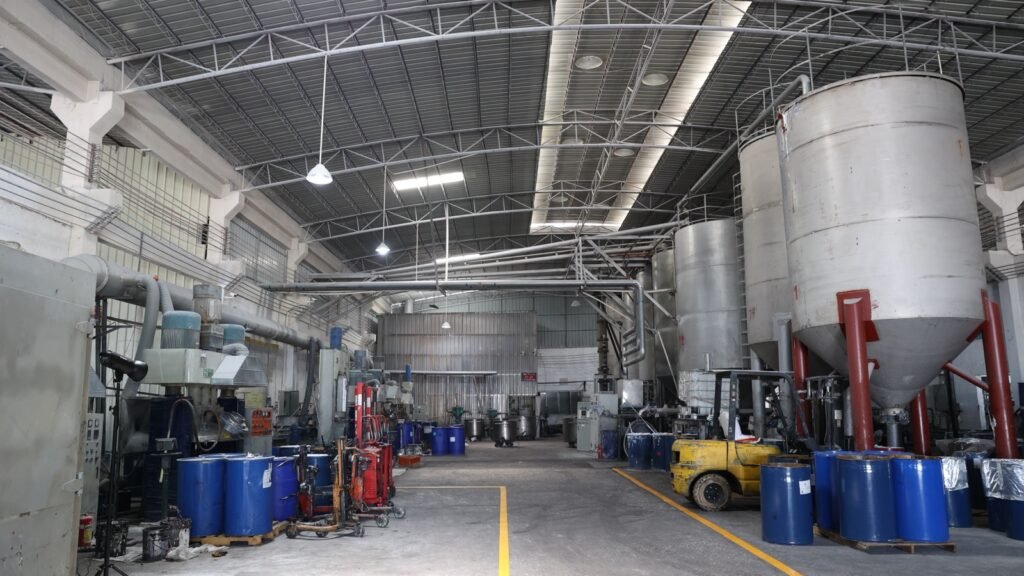 Sealant production area with mixing vessels, processing equipment and blue material drums.