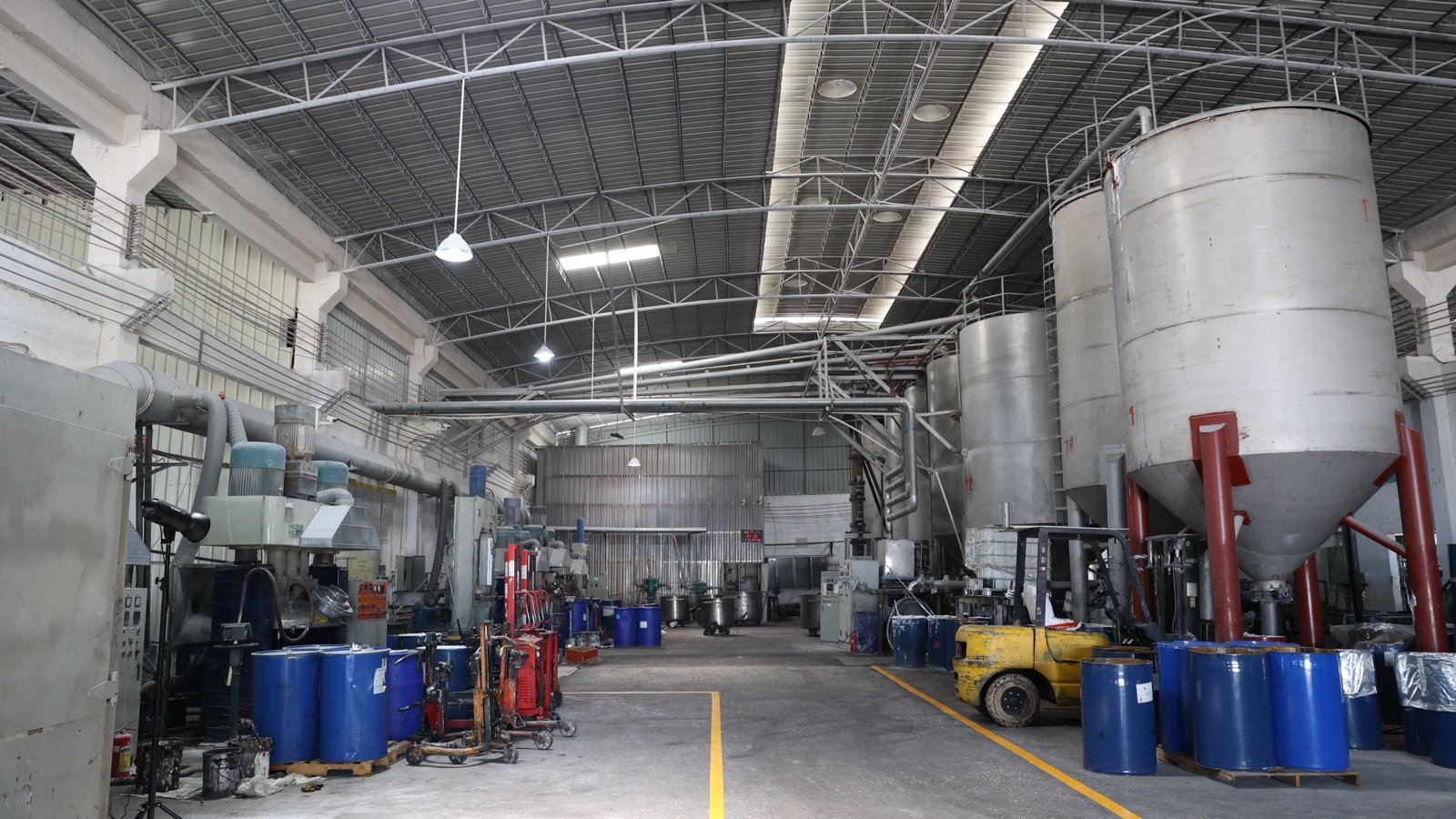 Sealant production area with mixing vessels, processing equipment and blue material drums.