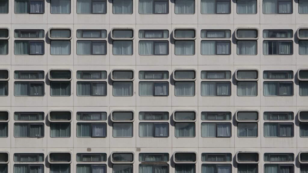 Repeating rows of window openings and facade panels on a multi-story building.