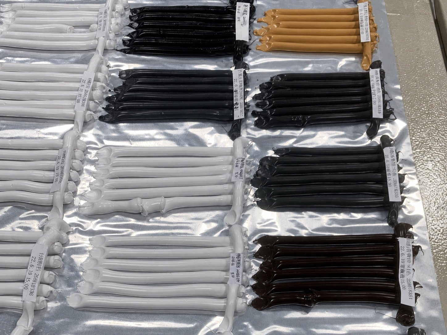 Prepared sealant bead samples grouped by color with identification tags.