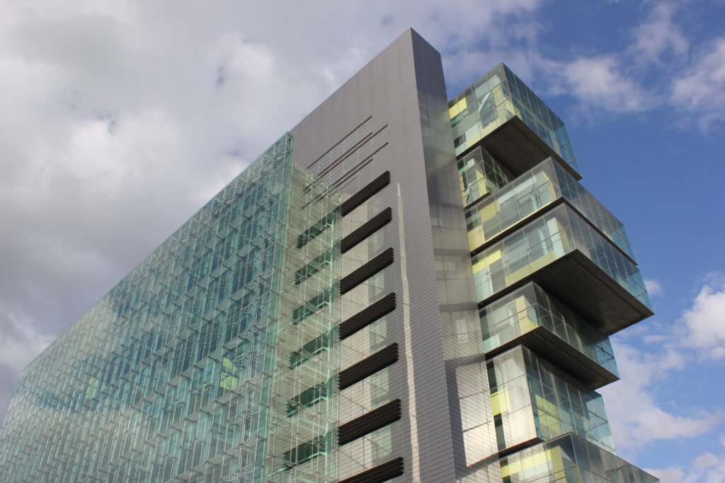 The glazed glass curtain wall of the Manchester Civil Justice Centre viewed from outside.