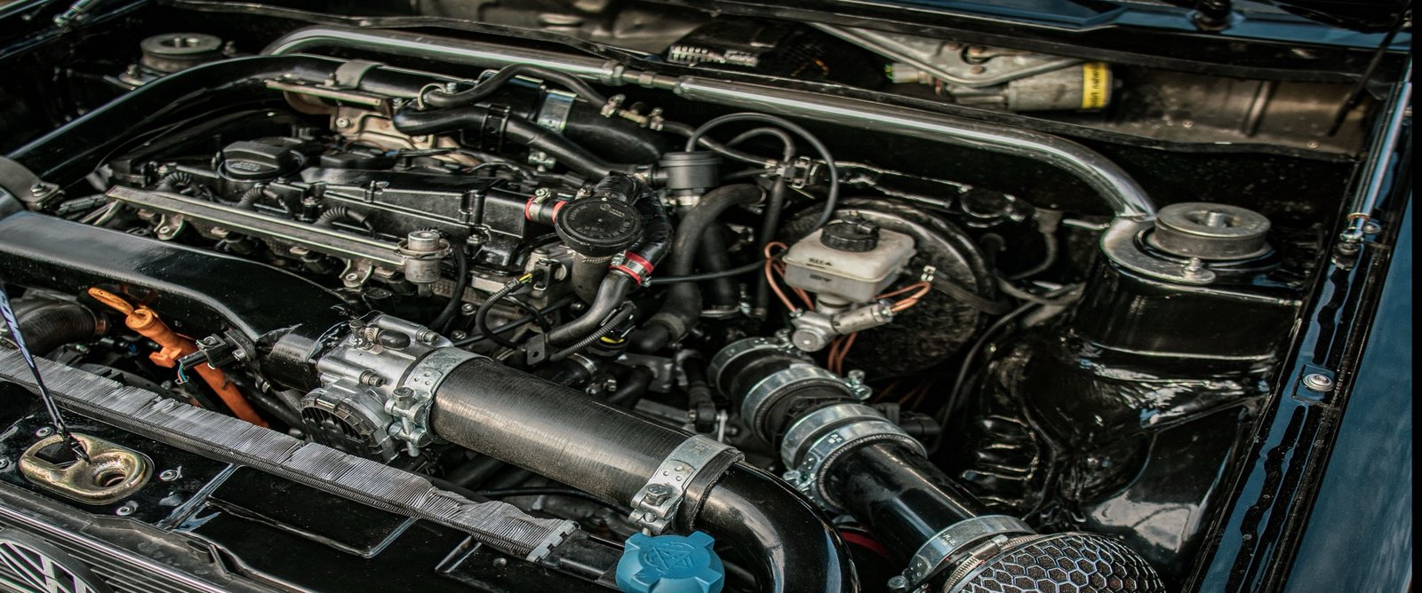 Close view of bolted engine components and mating-cover geometry in an engine bay.