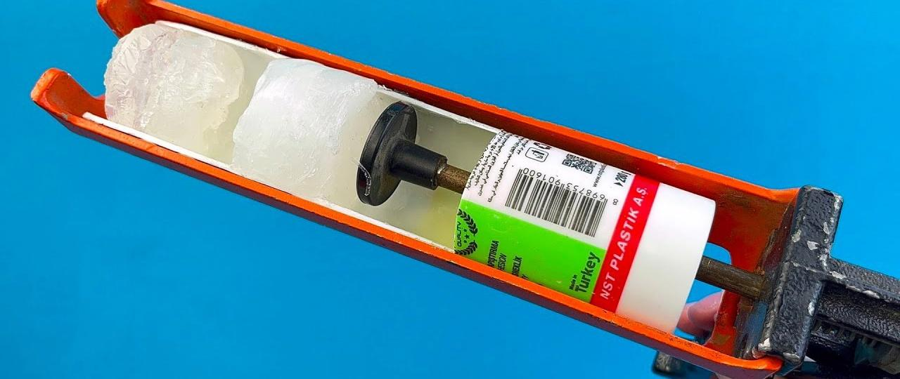 Open caulk cartridge showing hardened white sealant inside the barrel.