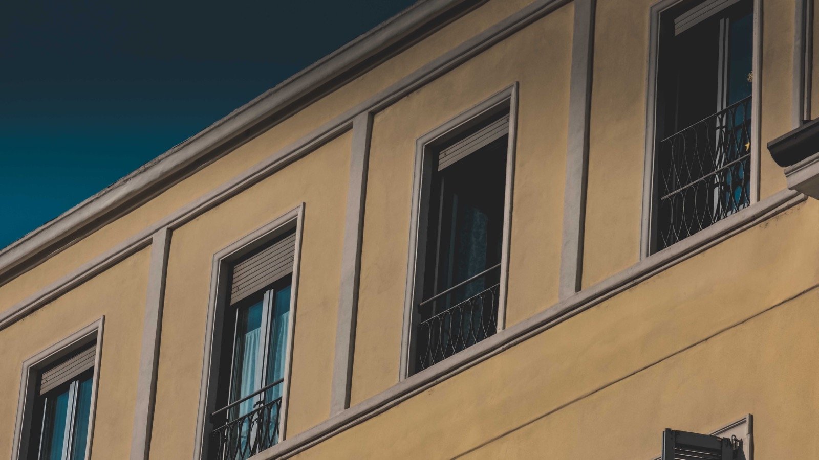 Sunlit exterior building facade with window perimeters and exposed weather joints.