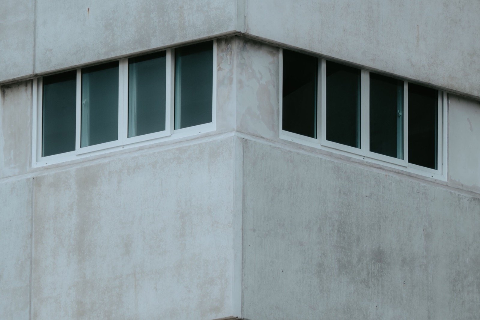 Close exterior facade corner showing windows, panel interfaces and exposed perimeter joints.