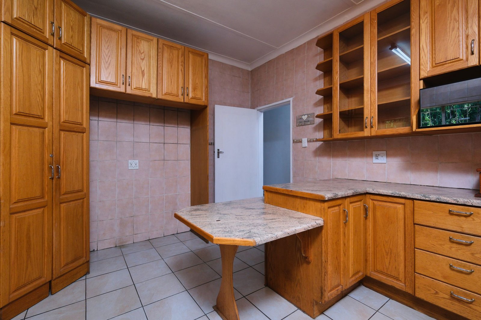 Wooden kitchen cabinets and a countertop in an interior kitchen.