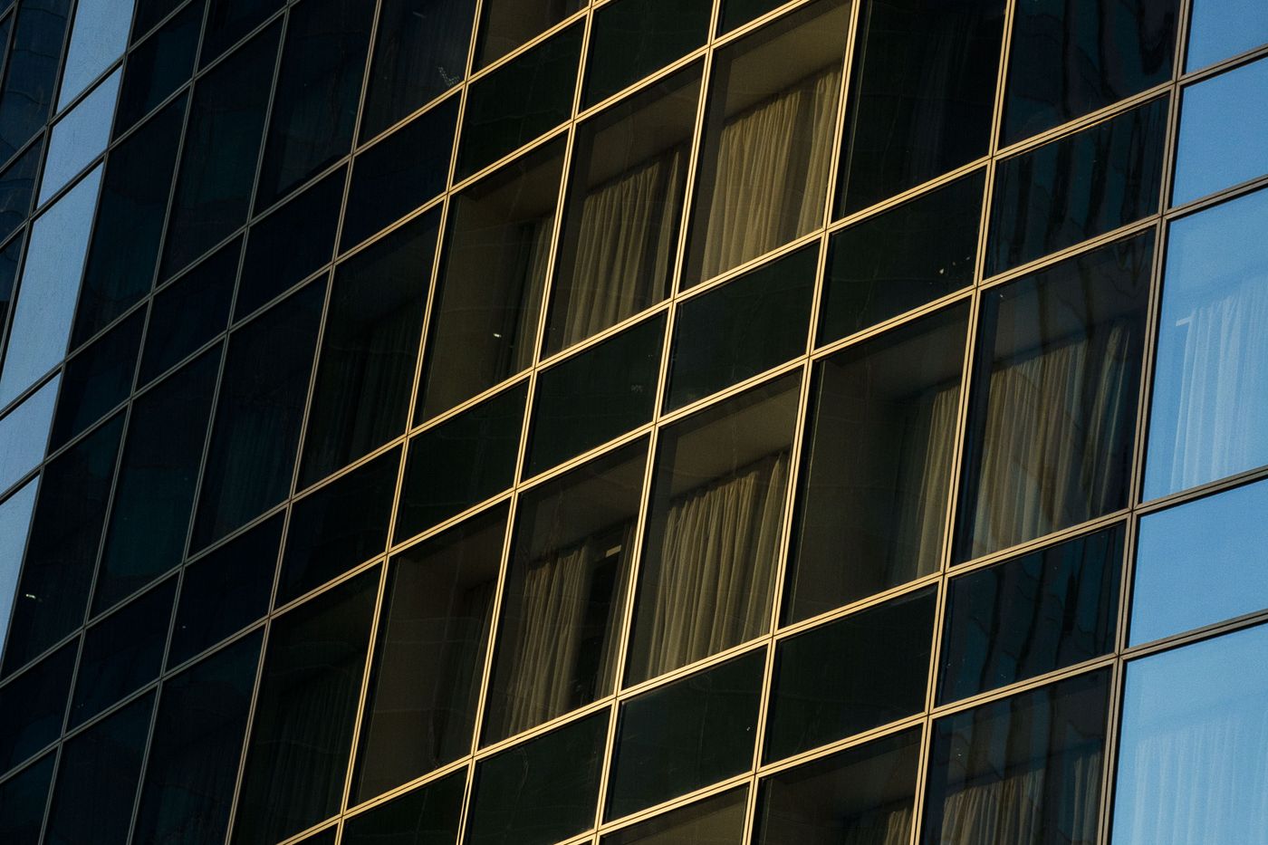 Panneaux architecturaux en verre et en métal divisés par des lignes de joint épurées.