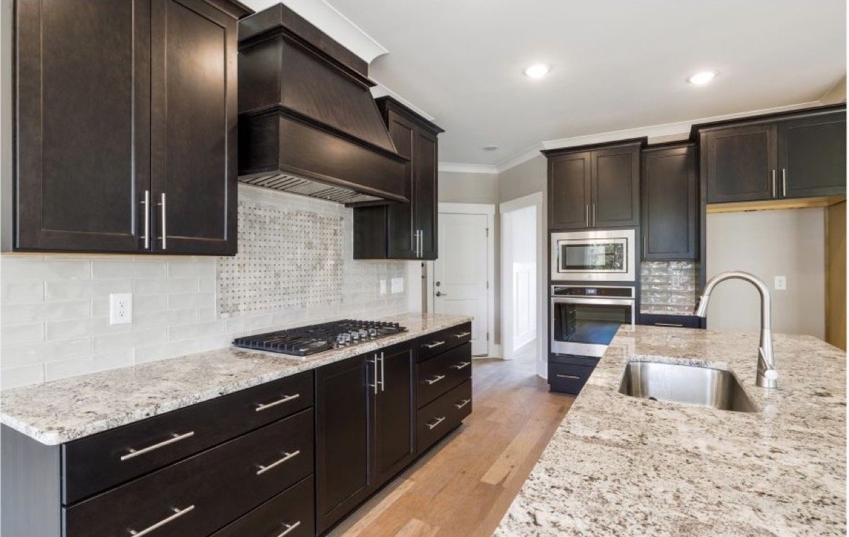 Granite countertop with an undermount sink and backsplash in a finished kitchen.